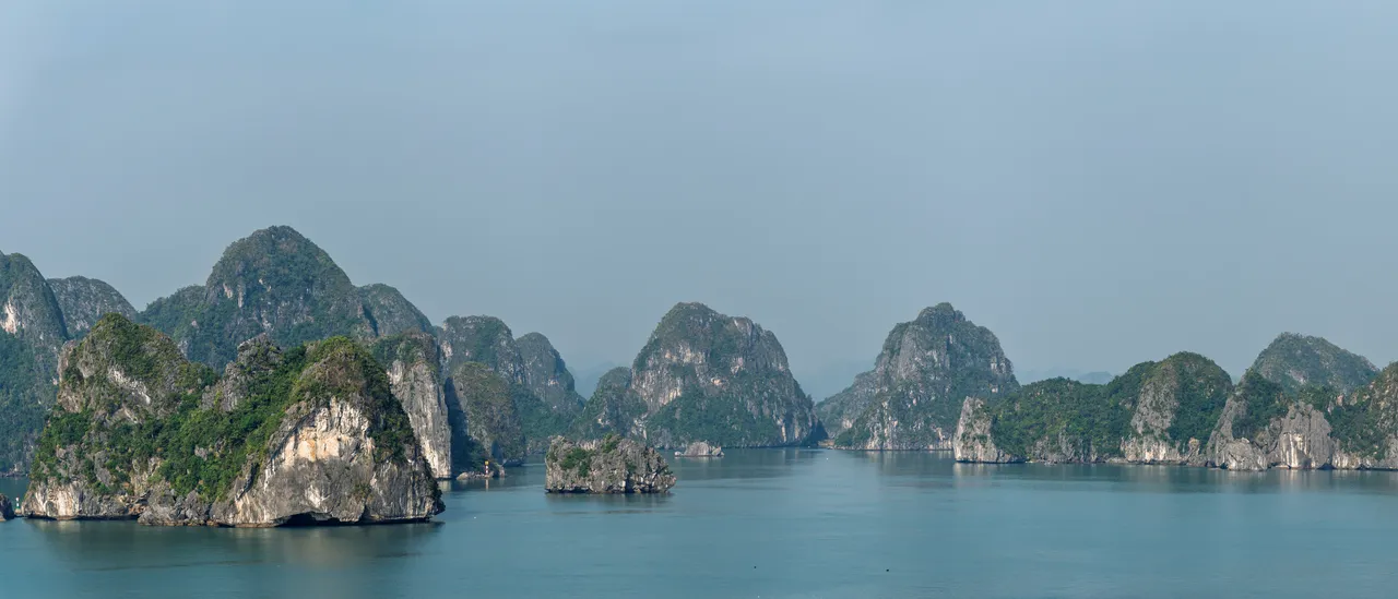 Pains de sucre karstiques de la baie d’Halong émergeant d’une mer calme